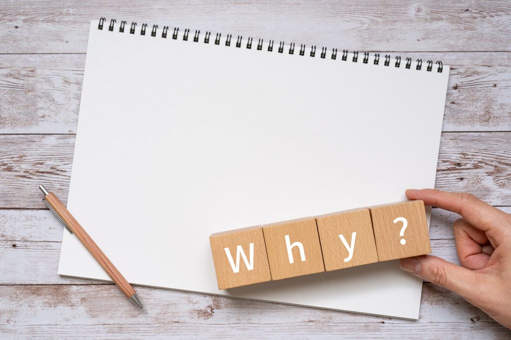 紙と鉛筆と「why」と書かれた積み木