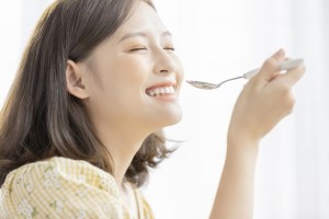 スプーンで食事をする女性