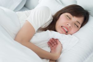 くいしばりをして寝ている女性